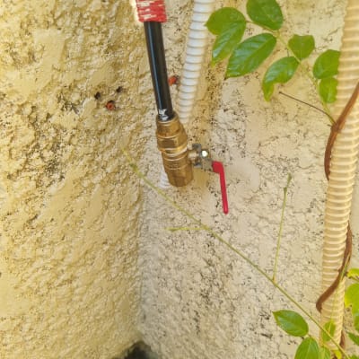 צינור מים עם ברז פליז על קיר חיצוני