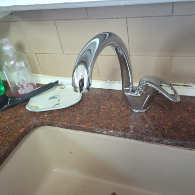 ברז מטבח עם חומרי ניקוי על השיש