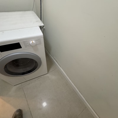 מכונת כביסה עם צינור מים על הקיר