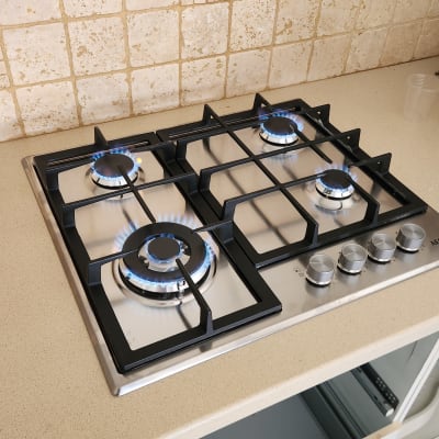 כיריים גז עם להבות כחולות על משטח מטבח