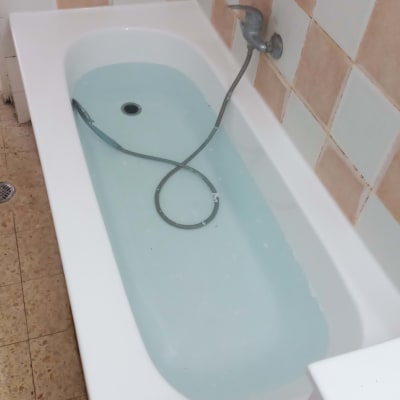 אמבטיה עם מים, אריחים בצבעים שונים על הקיר