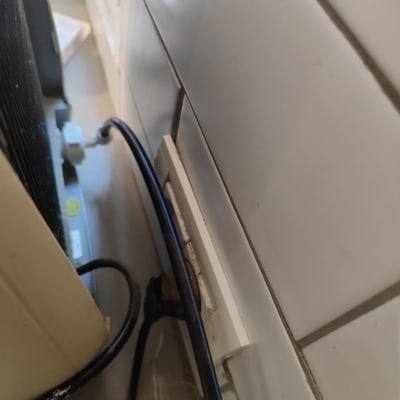 צינור מים ליד קיר עם אריחים לבנים