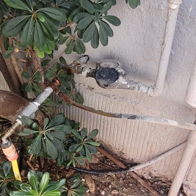 צנרת מים עם ברזים ומד מים ליד קיר