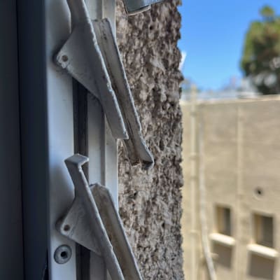 תריסים לבנים עם ידיות מתכת על קיר חיצוני