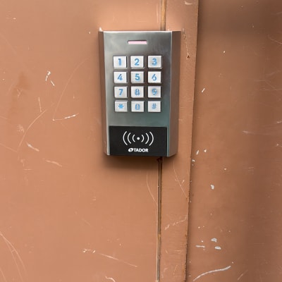 לוח מקשים מתכת עם מספרים על דלת חומה