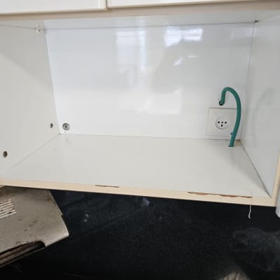 ארון מטבח פתוח עם שקע חשמל וצינור ירוק