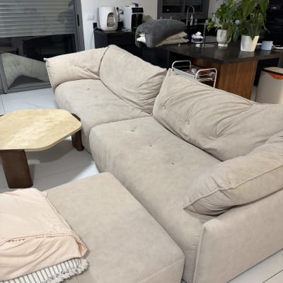 ספה בהירה בחדר מגורים עם שולחן קטן