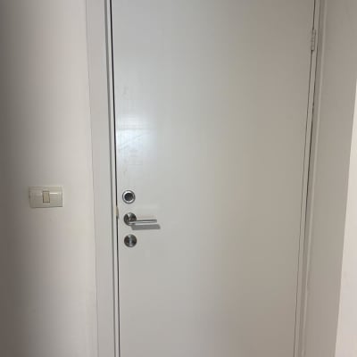 דלת לבנה עם ידית כסופה בקיר לבן