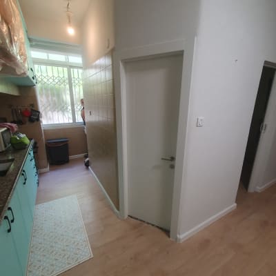 דלת לבנה עם ידית כסופה במסדרון צר