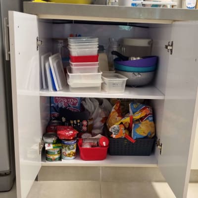 ארון מטבח פתוח עם קופסאות פלסטיק ומזון