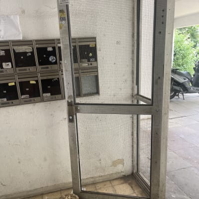 דלת מתכת עם רשת פתוחה ליד תיבות דואר