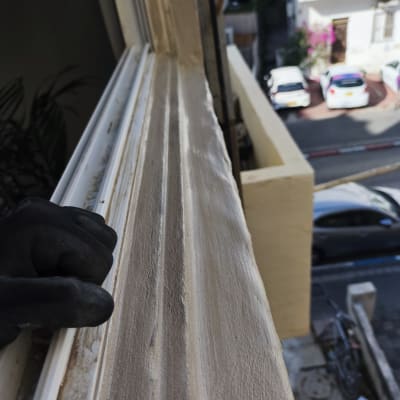 עבודת תחזוקה על אדן חלון עם כפפה שחורה