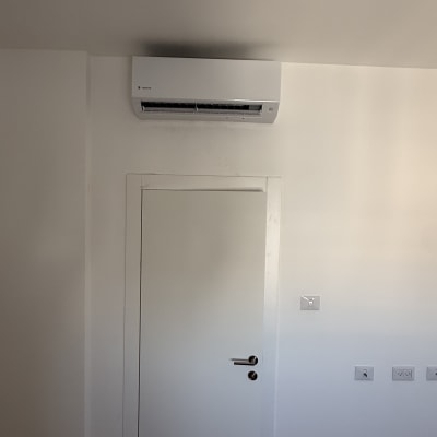 מזגן מותקן מעל דלת בחדר לבן
