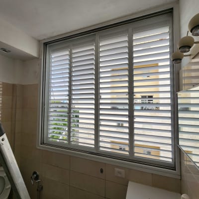 חלון עם תריסים סגורים בחדר אמבטיה