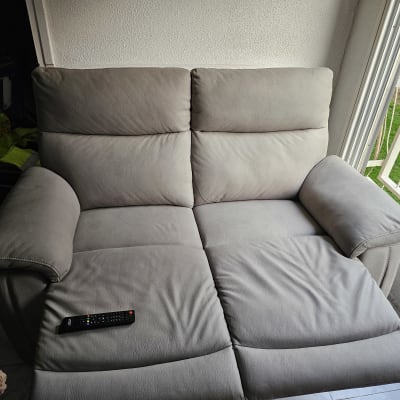 ספה אפורה עם שלט רחוק מונח עליה