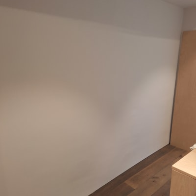 קיר צבוע בצבע לבן עם רצפת עץ