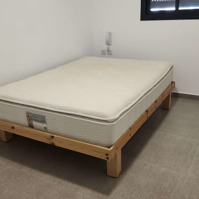 מיטה עם מזרן בחדר ריק