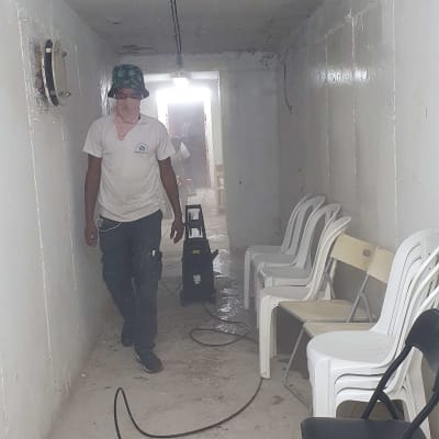 אדם במסדרון עם מכונת ניקוי וכיסאות
