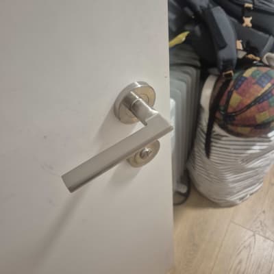 ידית מתכתית מעוצבת מותקנת על דלת פנים לבנה