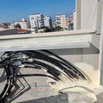 חוטים אטומים בקיר עם חומר איטום לבן