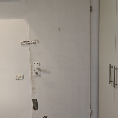 דלת לבנה עם קילופי צבע ופגמים בתחתית