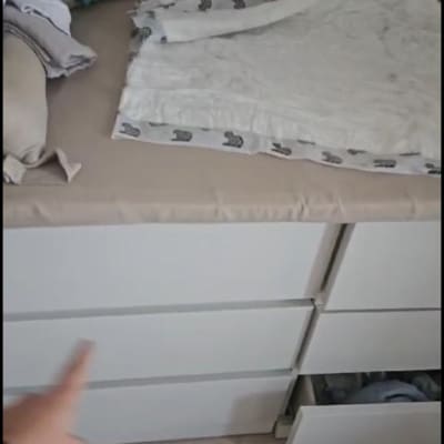 אדם מצביע על מגירה פתוחה בארון לבן