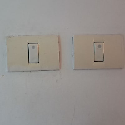 שני מתגי חשמל על קיר לבן