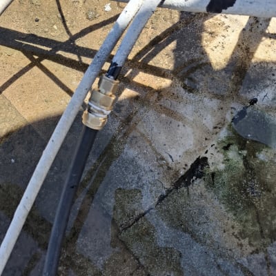 צינור עם מחבר מתכת על רקע רטוב