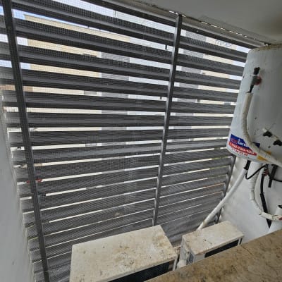 רשת מתכת מותקנת על חלון למניעת כניסת יונים