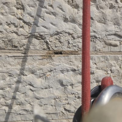 חבל אדום וגלגלת על קיר אבן מחוספס