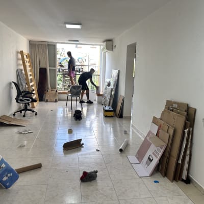 אנשים עובדים בחדר עם קרטונים וציוד מעבר