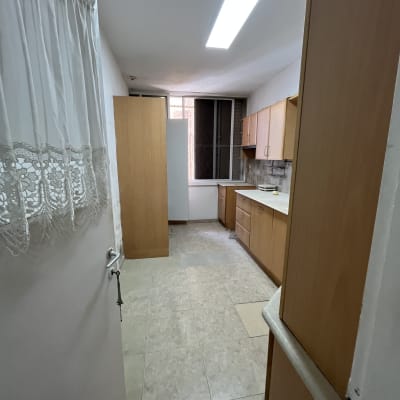 מטבח ריק עם ארונות עץ ותאורה עליונה