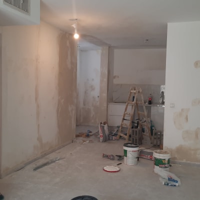 חדר בשיפוץ עם סולם, דליים וכלי עבודה