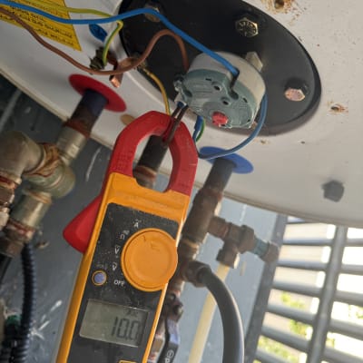 מד זרם חשמלי מחובר לחוטים במערכת חשמל