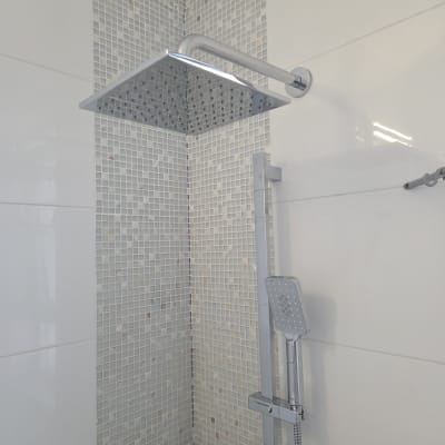 מקלחת עם ראש מקלחת מרובע על קיר אריחים