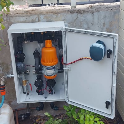 מערכת השקיה עם מסנן כתום וצינורות בגינה