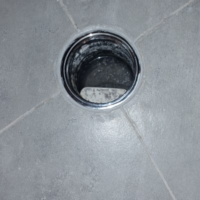 פתח ניקוז עגול ברצפה אפורה