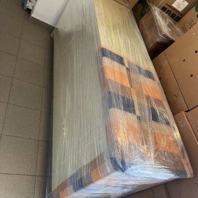 מזרן עטוף בניילון עם קופסאות קרטון מסביב