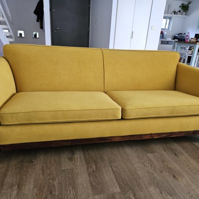 ספה צהובה עם ריפוד מרופד על רצפת עץ