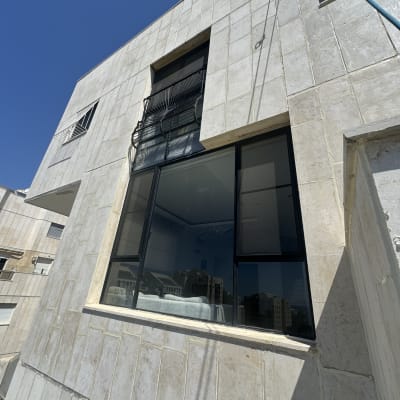 חזית בניין עם חלונות גדולים ומעקה ברזל