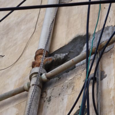 צינורות מתכת וחוטי חשמל על קיר חיצוני