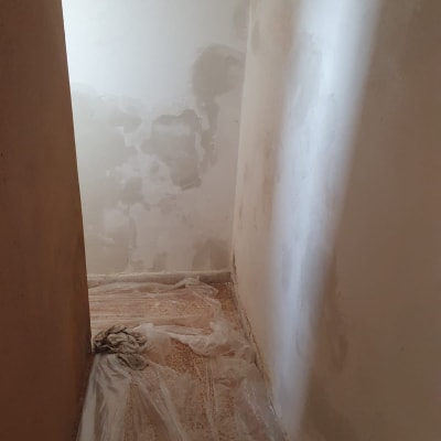 קיר עם תיקוני צבע ויריעות פלסטיק על הרצפה