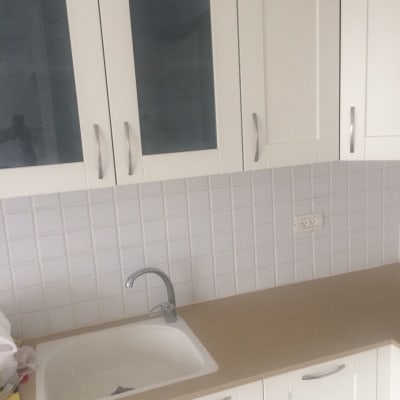 ארונות מטבח לבנים עם ידיות מתכת וכיור לבן