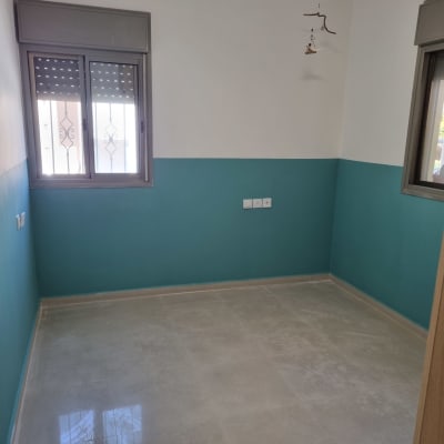 חדר עם קירות צבועים, רצפה חדשה ודלי צבע