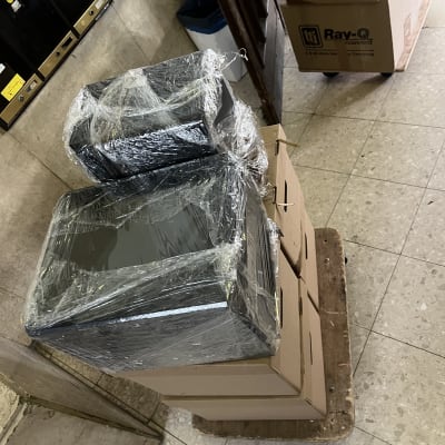 ציוד מחשבים עטוף בניילון נצמד וארגזי הובלה על עגלת משא