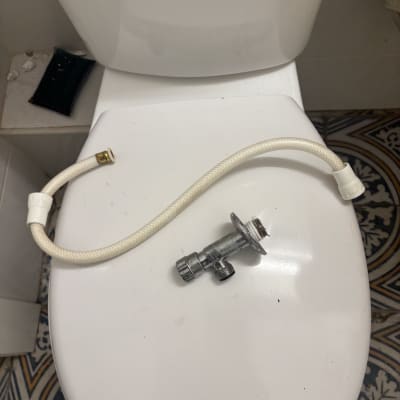 אסלה עם צינור וחלק מתכת מונחים עליה
