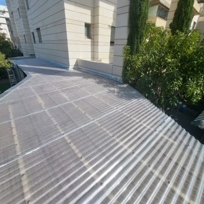 גג מתכת גלי ליד עצים ירוקים