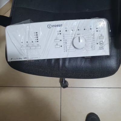 לוח בקרה של מכונת כביסה אינדסיט עם כפתורים ומתגים.