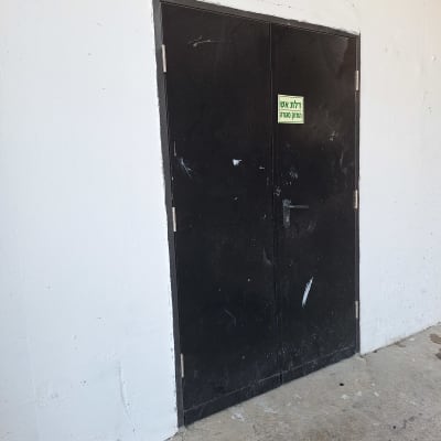 דלת מתכת שחורה עם ידית ומנעול