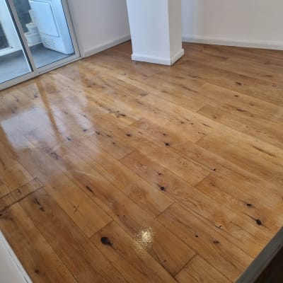 רצפת פרקט עץ מבריקה בחדר עם קיר לבן